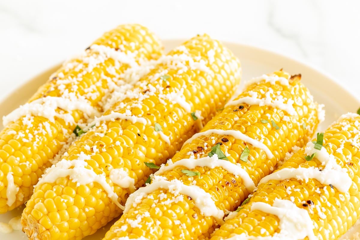 Mexican street corn on a white platter.