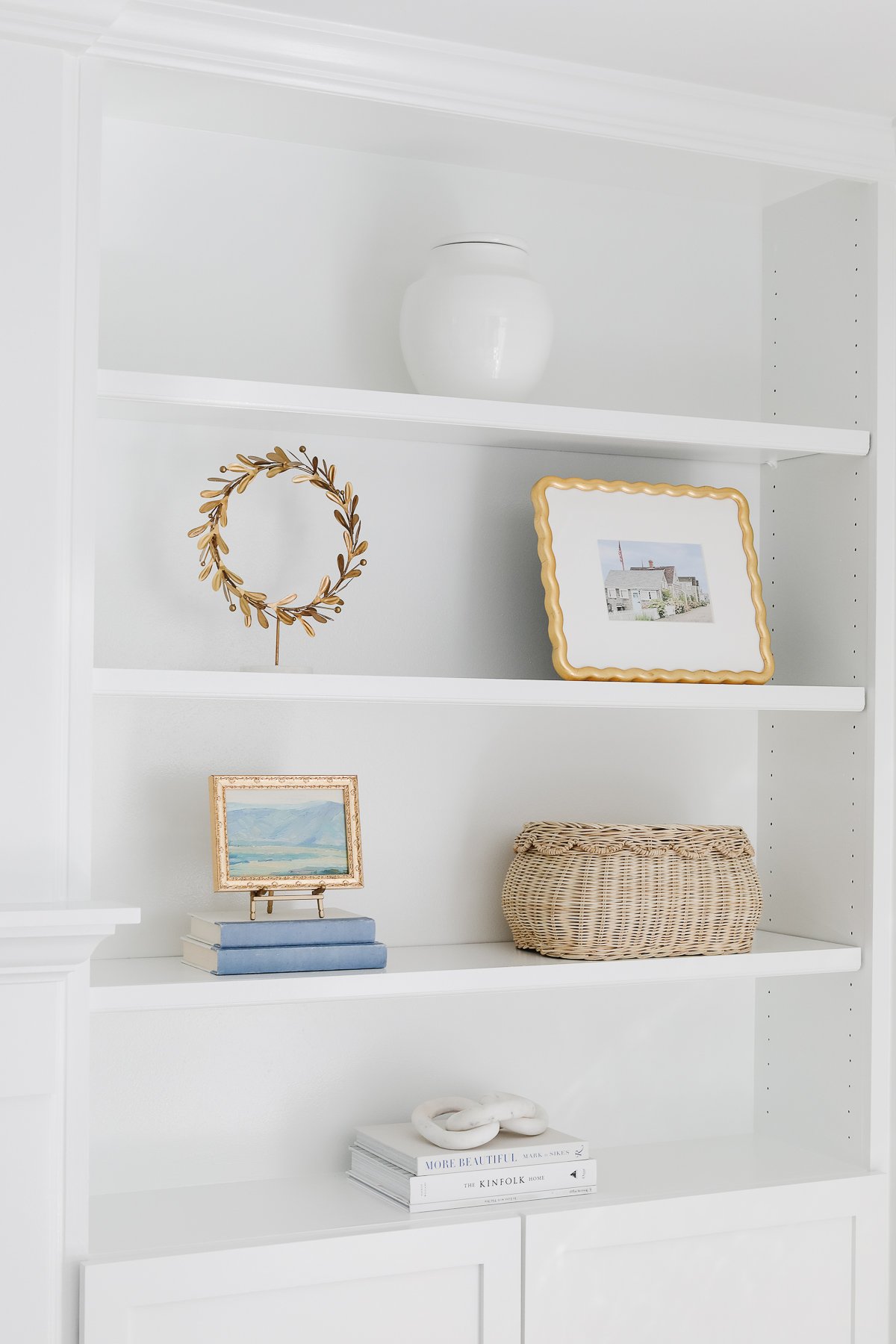 White bookshelves styles with a scalloped basket for organization.