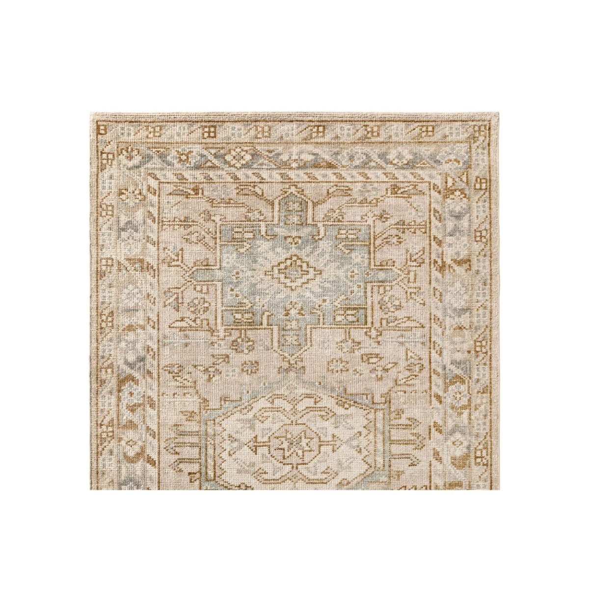 Corner of a beige and light blue patterned rug with geometric and floral designs, capturing that coveted Pottery Barn look for less.