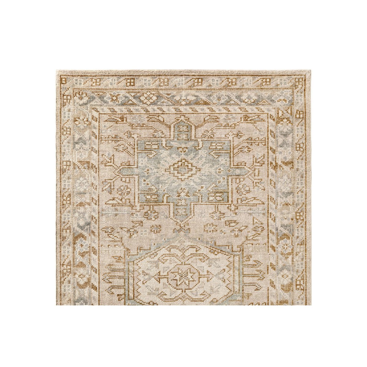 Corner of a beige and light blue patterned rug with geometric and floral designs, capturing that coveted Pottery Barn look for less.