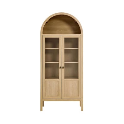 A wooden cabinet with an arched top, glass doors, and three interior wooden shelves offers a sophisticated yet affordable solution for achieving the Pottery Barn look for less.