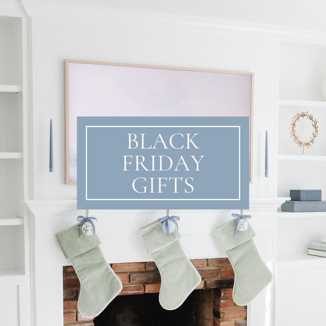 A white mantel with three green stockings hanging over a cozy fireplace showcases a large square sign announcing "Black Friday Gifts." It's the perfect setting to find unbeatable deals reminiscent of Prime Day celebrations.