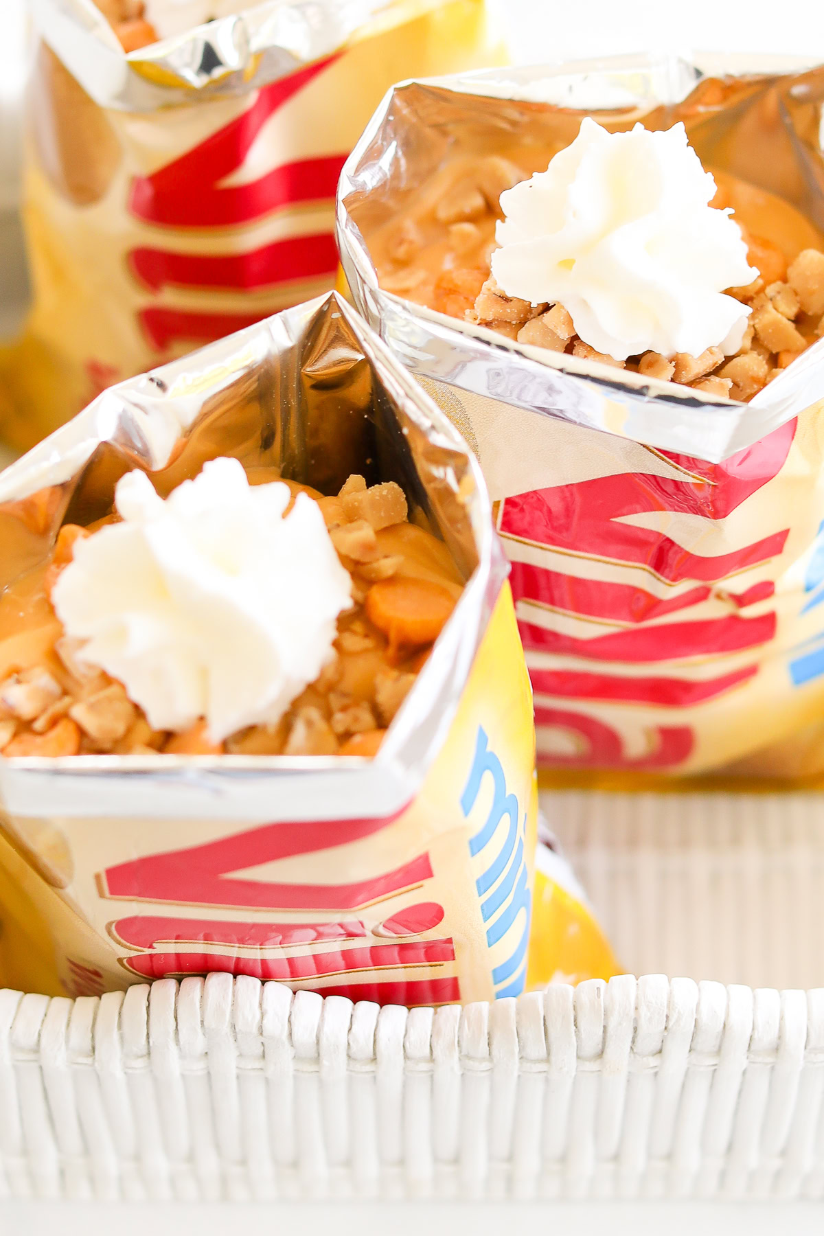 Open bags of chips filled with toppings and whipped cream, reminiscent of a whimsical butterscotch pie in a bag.