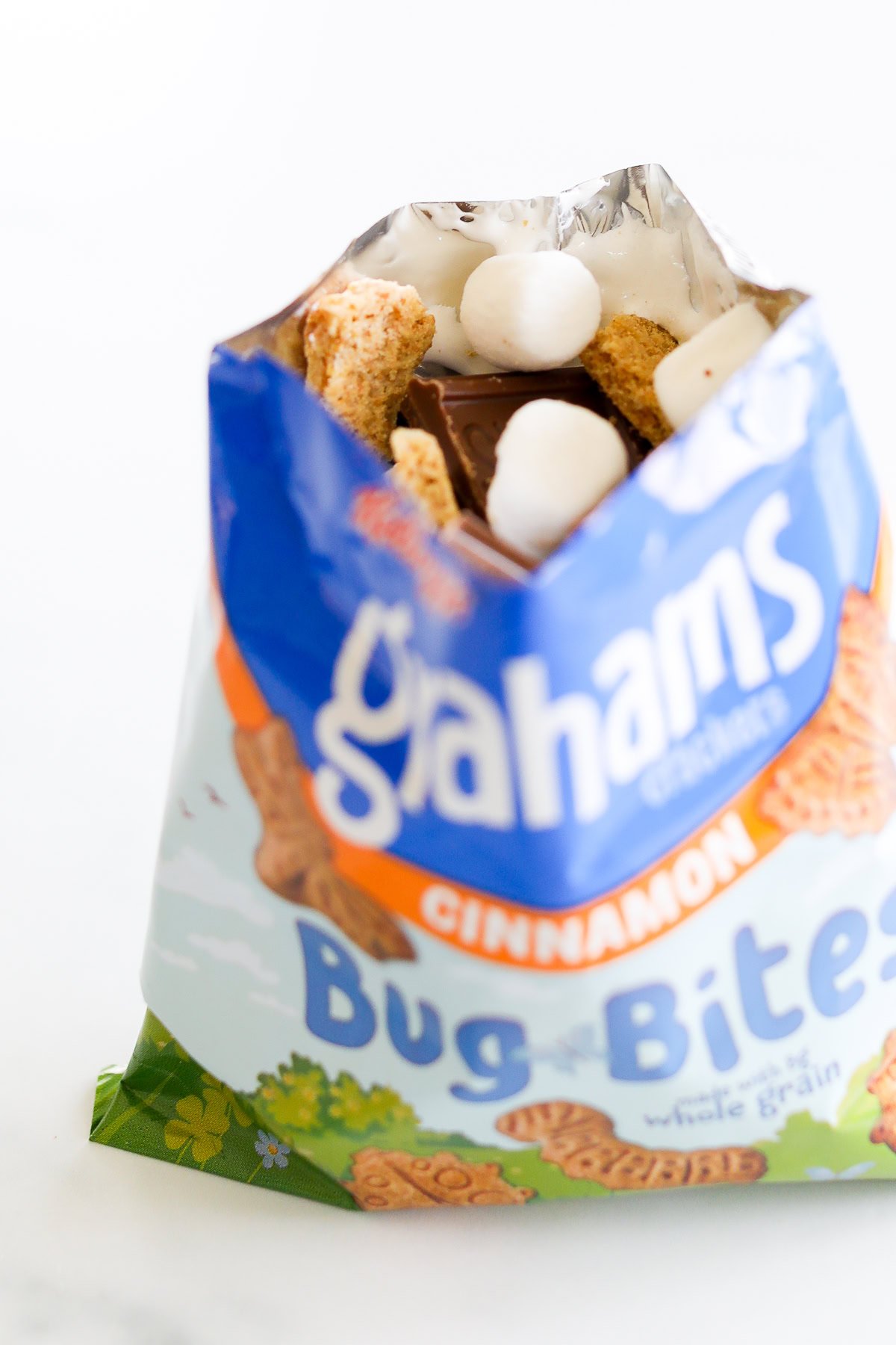 An open bag of graham crackers with chocolate and marshmallows inside for walking smores.