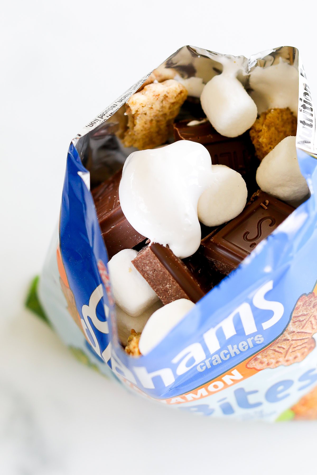 An open bag of graham crackers with chocolate and marshmallows inside for walking smores.