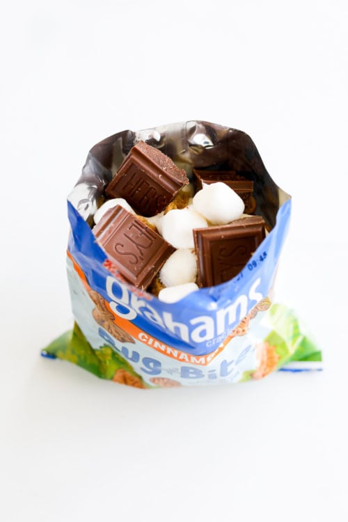 An open bag of graham crackers with chocolate and marshmallows inside for walking smores.