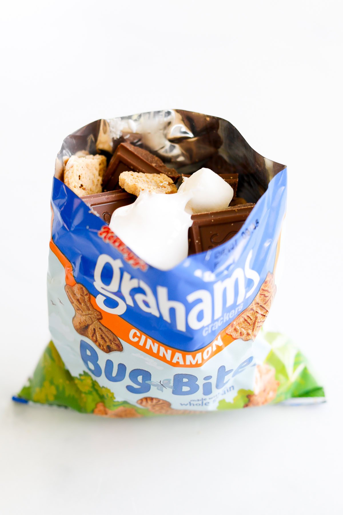 An open bag of graham crackers with chocolate and marshmallows inside for walking smores.