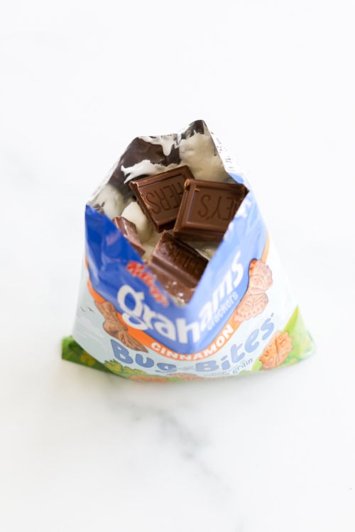 An open bag of graham crackers with chocolate and marshmallows inside for walking smores.