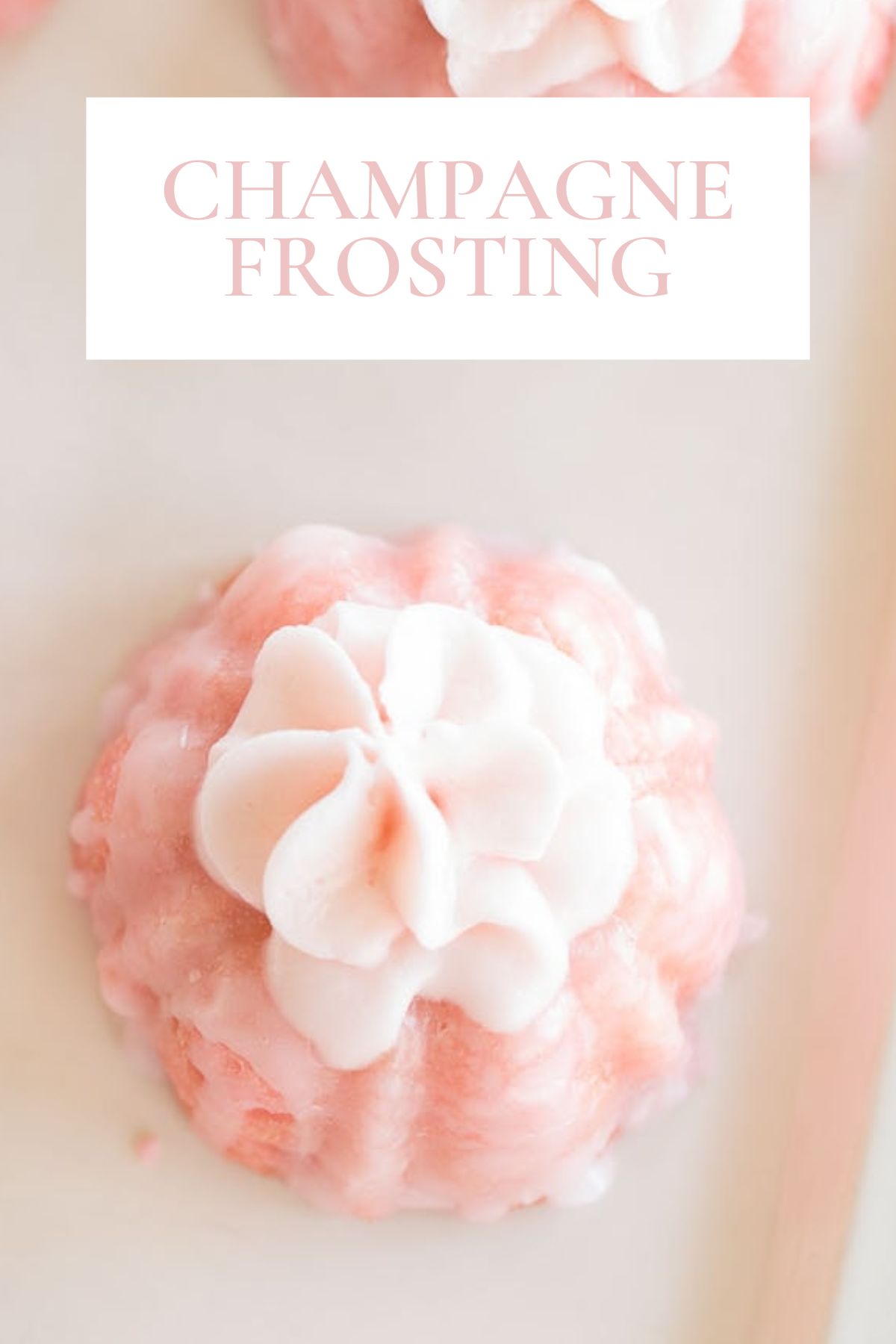 A delightful pink cupcake adorned with a swirl of white frosting, elegantly topped with the words "Champagne Frosting.