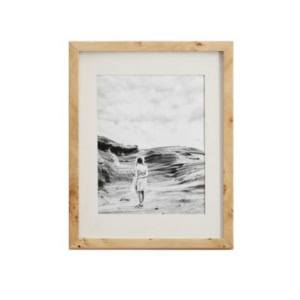 A framed black-and-white photo of a person standing outdoors on a rocky landscape under a cloudy sky, offering that sought-after Pottery Barn look for less.