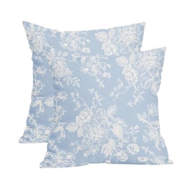 Two light blue square pillows with white floral patterns are stacked against a plain white background, offering a chic Pottery Barn look for less.