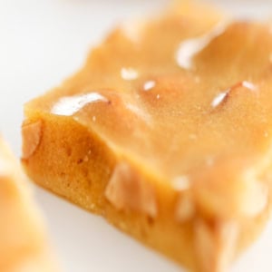 A close-up of peanut brittle reveals its glossy, caramelized surface with visible peanuts, showcasing the irresistibly crunchy delight.