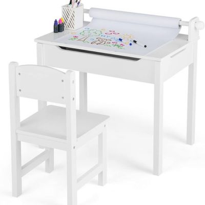 A white children's desk serves as a perfect craft space idea, topped with a roll of drawing paper showcasing colorful art. It includes a chair and a cup holding markers and pencils.