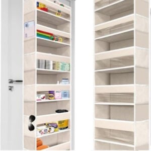 The white over-the-door storage organizer with multiple pockets is perfect for organizing crafts, displaying various items like cleaning supplies, toys, and small household products.