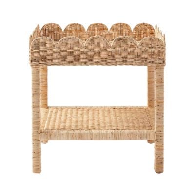 A wicker changing table with scalloped edges, four legs, and a lower storage shelf offers a Serena and Lily look for less, adding stylish charm and function to your nursery.