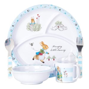 Children's dish set featuring a divided plate, bowl, cup, spoon, and fork with charming illustrations of a rabbit and garden motifs—perfect as Easter basket fillers.