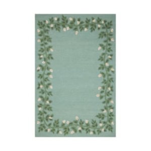 A rectangular light blue rug with a border of green leaves and white flowers—refer to our rug size guide to find the perfect fit for your space.