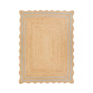 Rectangular area rug with scalloped edges in tan, featuring concentric blue and tan stripes near the border—refer to our rug size guide to find your perfect fit.