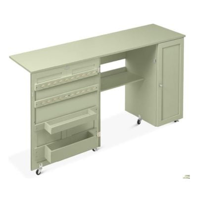 Explore craft space ideas with this green rolling craft table, perfect for organizing supplies. It features a spacious tabletop, side shelves, and a cabinet door, seamlessly blending form and function.