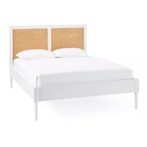 White bed frame with a cane headboard, dressed in white bedding and two pillows, set against a plain white background for a chic Serena and Lily look for less.