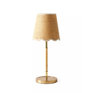 A table lamp with a woven, beige lampshade and gold-toned base and stem, offering a Serena and Lily look for less, photographed against a white background.