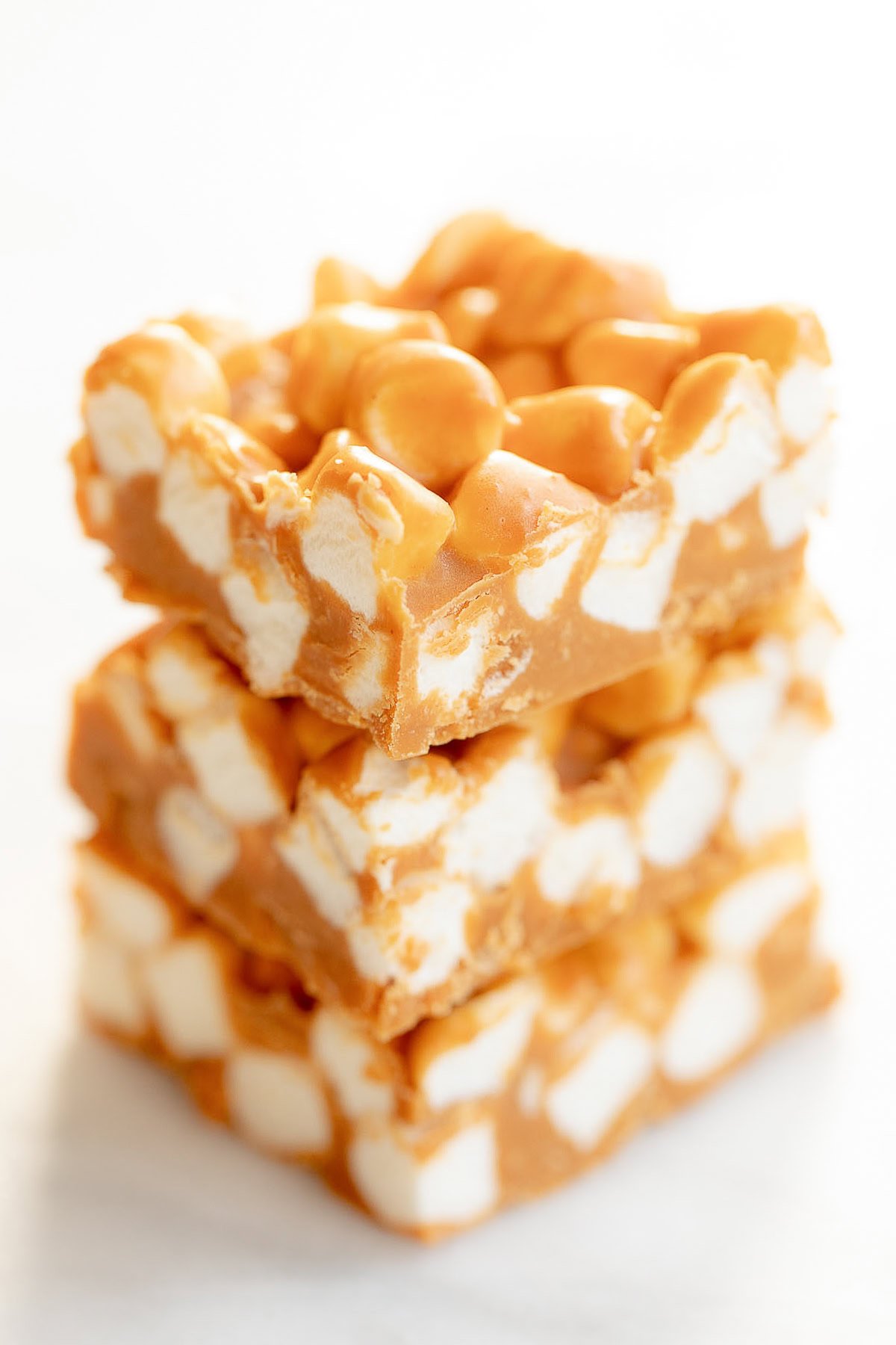 Three stacked peanut butter marshmallow squares with a creamy and chunky texture.