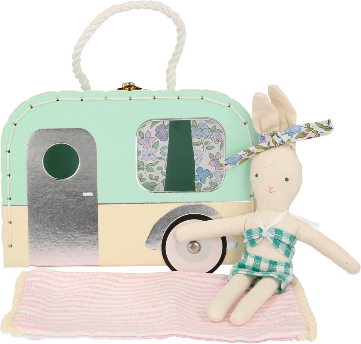 A fabric rabbit toy in a green checkered outfit with a floral headband sits on a pink striped mat. Perfect for Easter basket fillers, it is complemented by a mint and silver toy caravan with a floral window behind it.