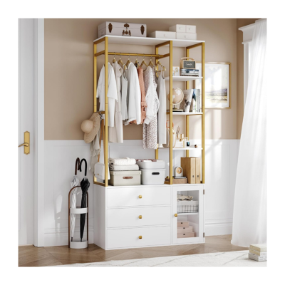 A neatly organized kids closet features white and gold accents, with hanging clothes, storage bins, drawers, and umbrellas set against a light brown and white wall. Sunlight filters softly through the curtains.