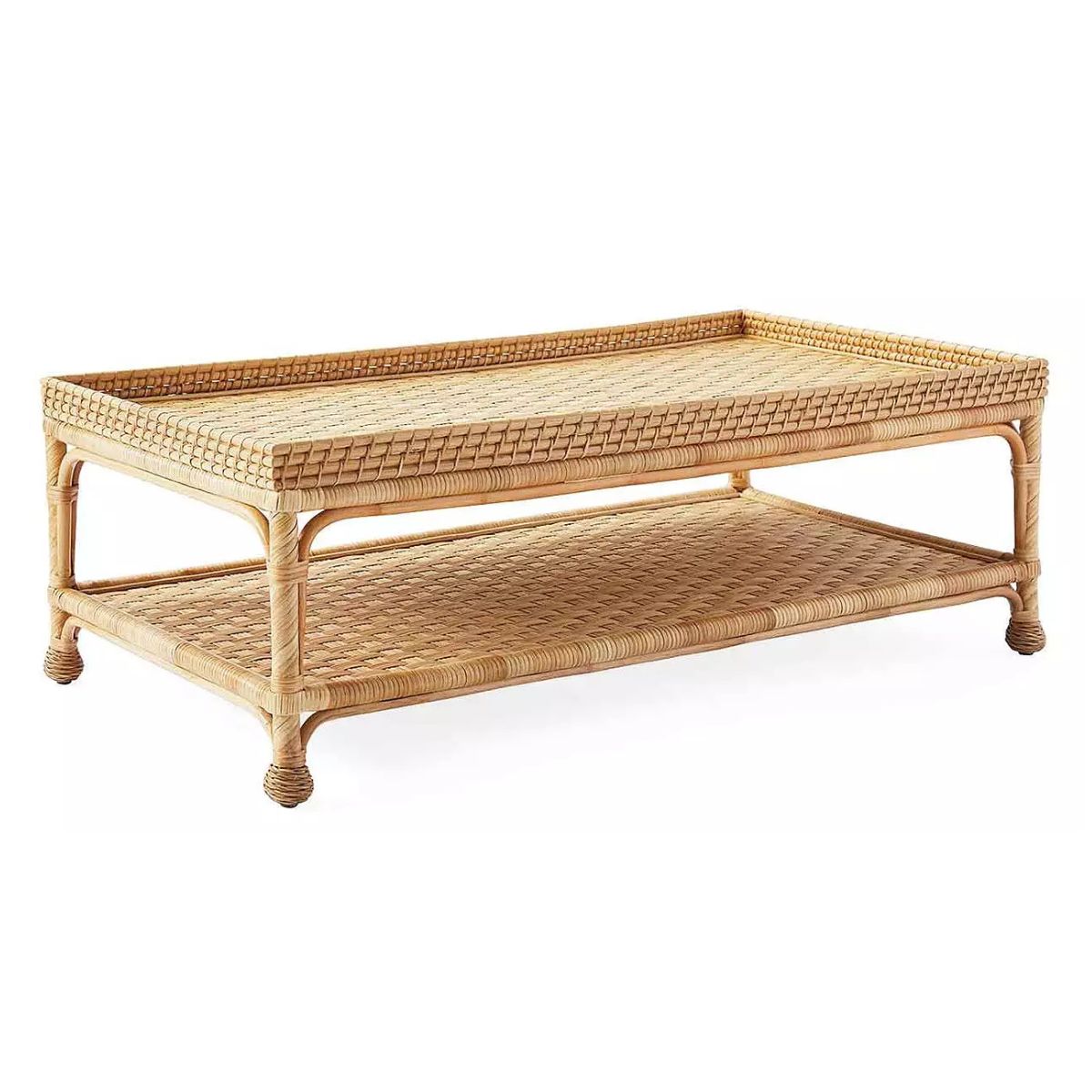 Rectangular woven rattan coffee table with a raised edge on top and an open lower shelf for storage, offering a stylish Serena and Lily look for less.
