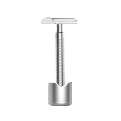 A silver safety razor with a textured handle stands upright in a matching metal holder against a plain white background, making it an elegant choice for unique Easter basket fillers.