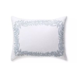 White rectangular pillow with a textured surface, featuring a light blue embroidered leafy border design around the edges—a perfect way to achieve the Serena and Lily look for less in your home décor.