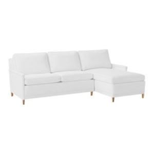 White Serena and Lily sectional sofa featuring three seat cushions, three back cushions, a right-side chaise lounge, and wooden legs on a plain background.