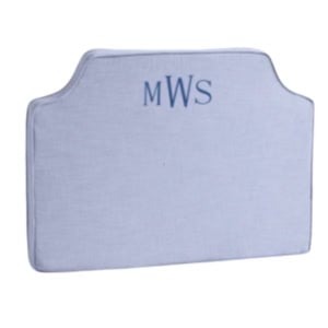 Light gray upholstered headboard with "MWS" monogram embroidered in blue at the center top.