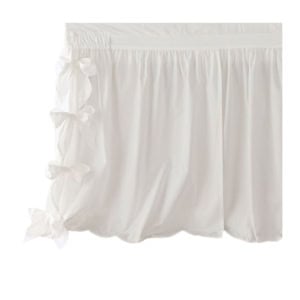 A white fabric skirt with a gathered waistband and three side bows on the left.