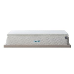 A Lucid brand mattress with a light-colored, textured cover is shown on a low, beige platform base against a white background.