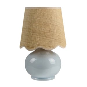 A table lamp with a glossy, round light blue ceramic base and a beige, textured fabric lampshade with a scalloped edge.