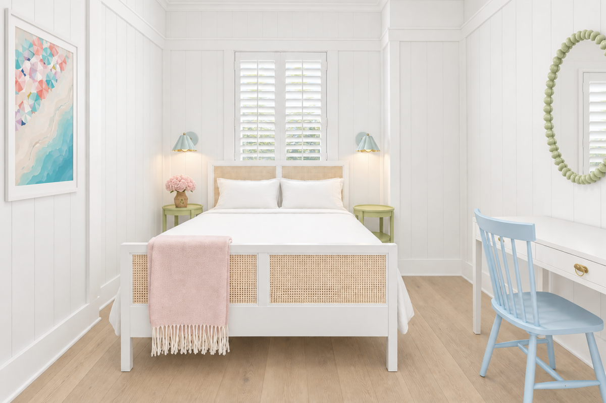 A bedroom with a white bed featuring cane paneling, a pink throw blanket, two green nightstands, a desk with a blue chair, and a round green mirror.