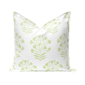 White throw pillow with a repeating light green floral pattern.